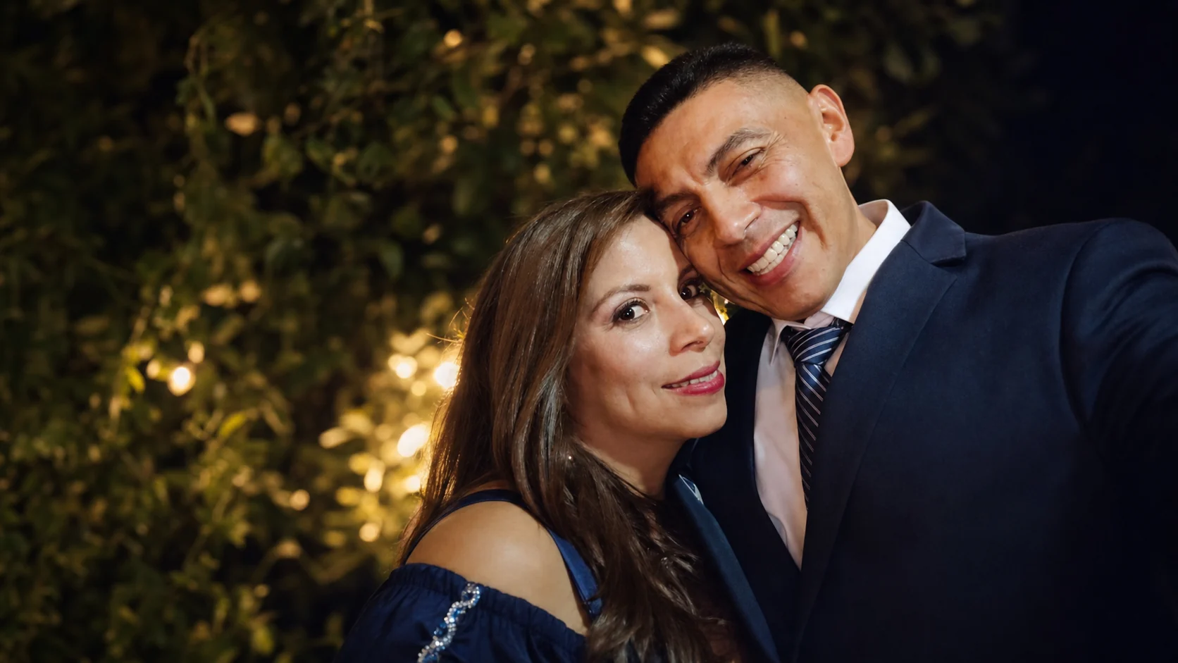 Retrato editorial de la pareja en un jardín iluminado